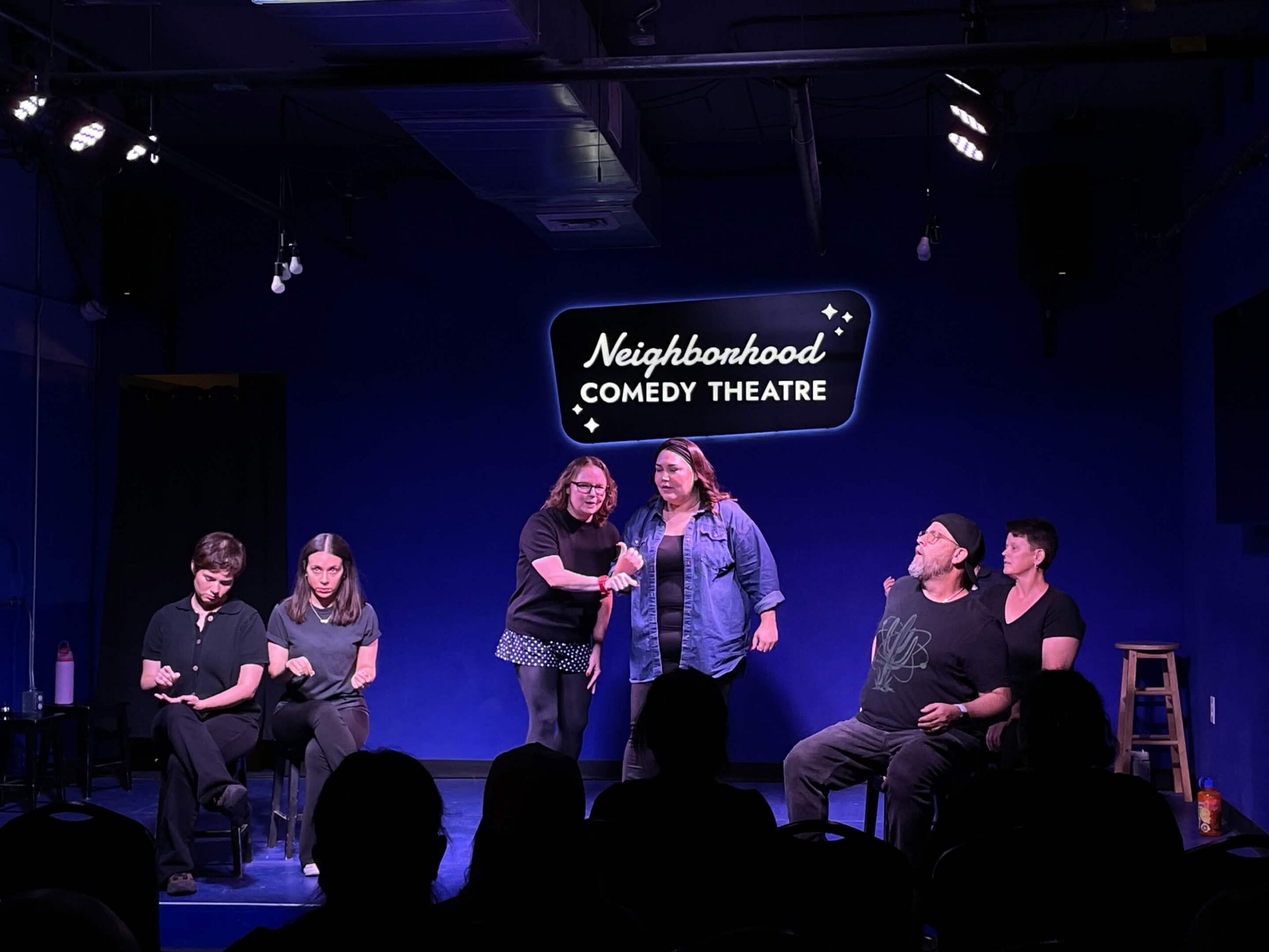 Improv students performing a Harold long-form scene on stage at the Neighborhood Comedy Theatre in downtown Mesa