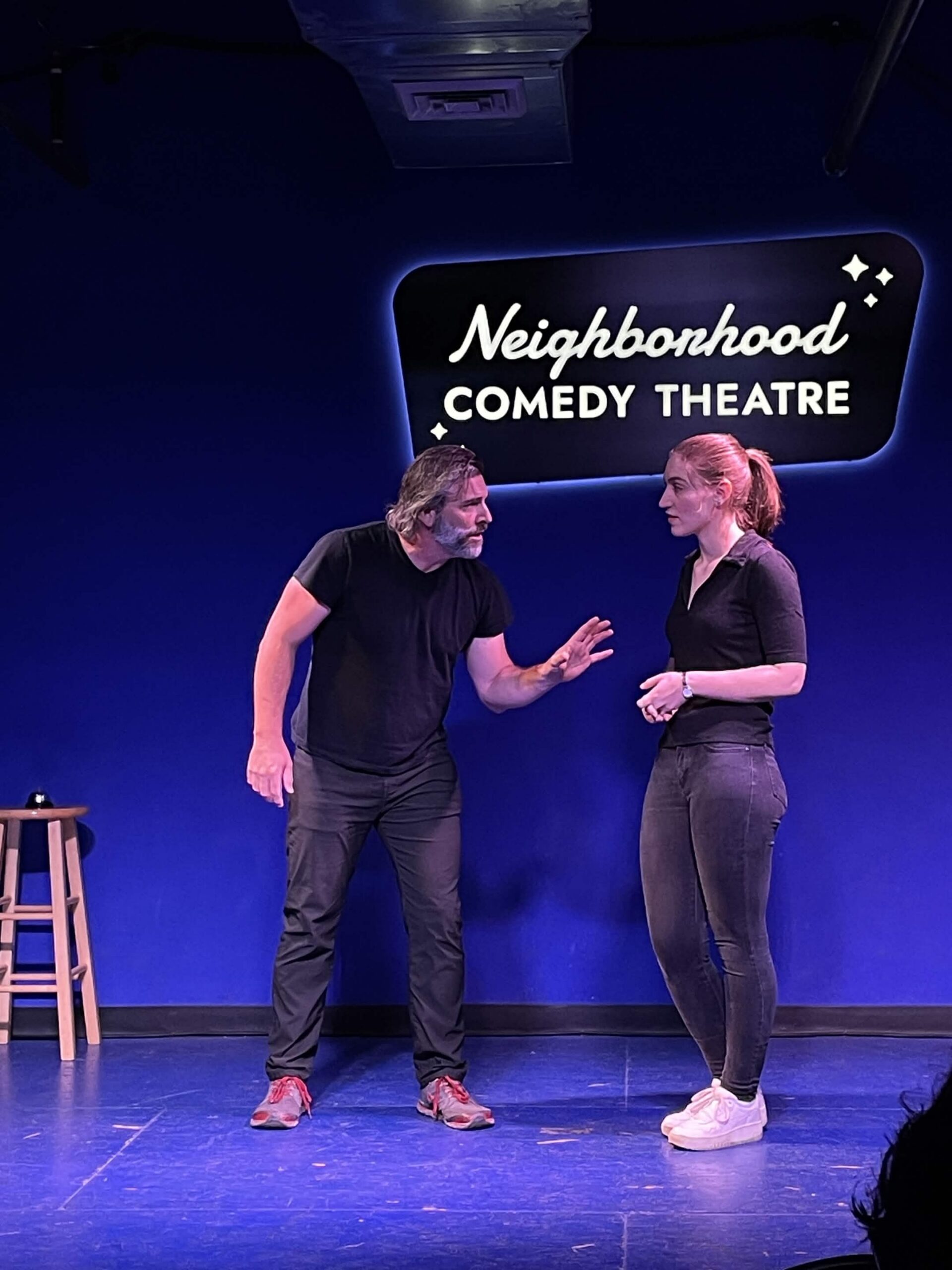 Improv students performing a Harold long-form scene on stage at the Neighborhood Comedy Theatre in downtown Mesa