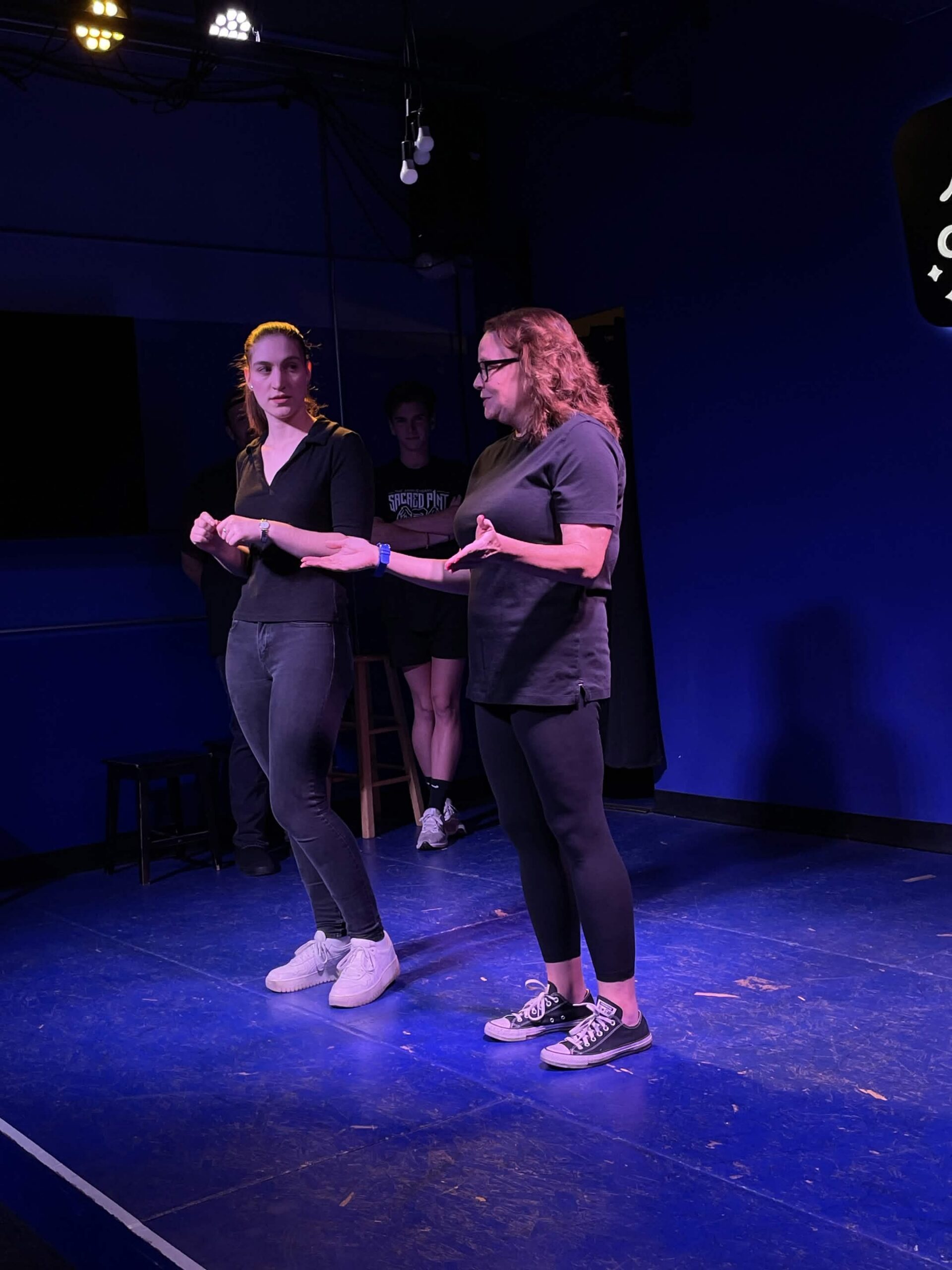 Improv students performing a Harold long-form scene on stage at the Neighborhood Comedy Theatre in downtown Mesa