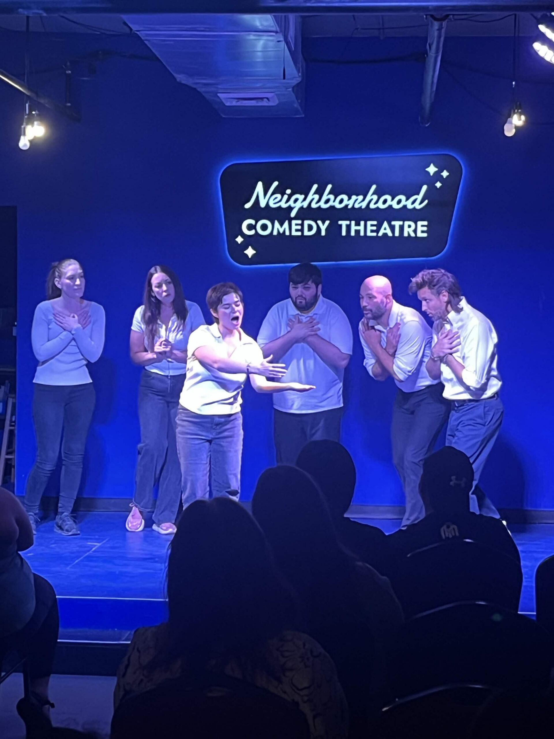 Improv students performing a Harold long-form scene on stage at the Neighborhood Comedy Theatre in downtown Mesa