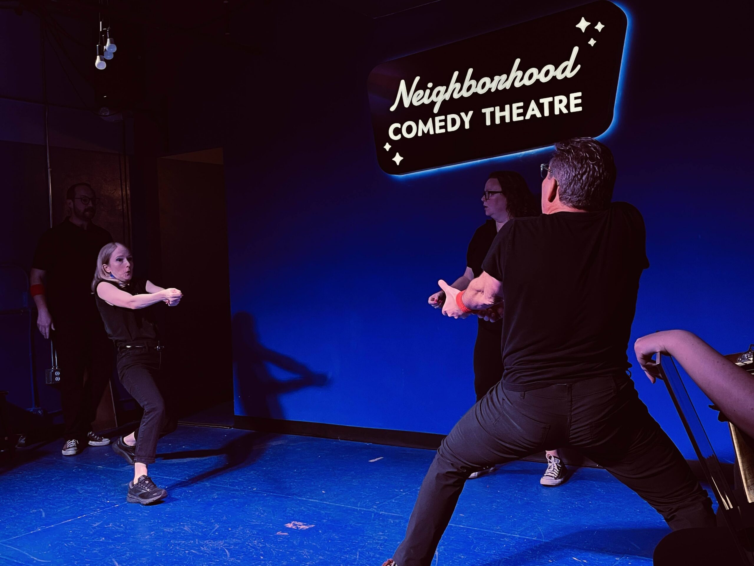 Improv students performing a Harold long-form scene on stage at the Neighborhood Comedy Theatre in downtown Mesa